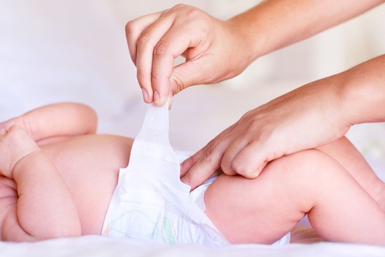 close up of parent's hands changing a baby's nappy