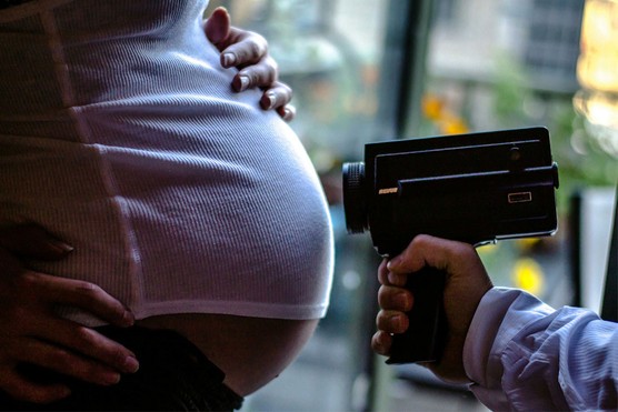 pregnant woman being filmed with movie camera