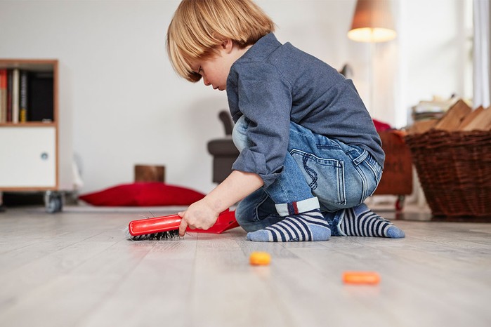 toddler using dustpan and brush