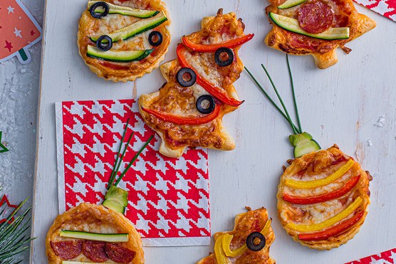 Annabel Karmel's festive puff pastry pizzas arranged on a board with Christmassy accessories