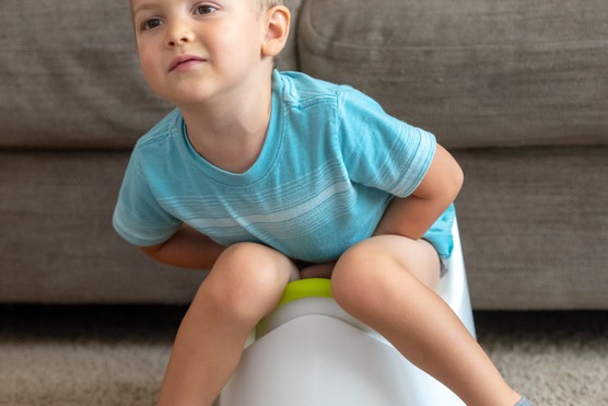 toddler with constipation sitting on a potty