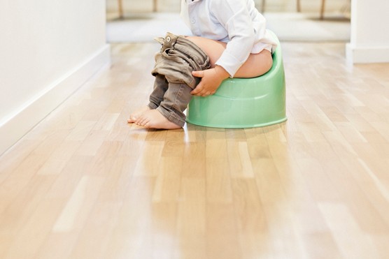 legs of boy sitting on potty