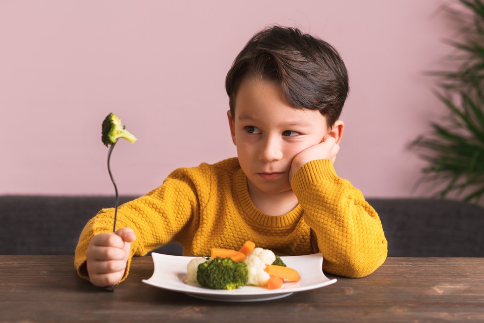 Child is very unhappy with having to eat vegetables. There is a lot of vegetables on his plate. He hates vegetables.