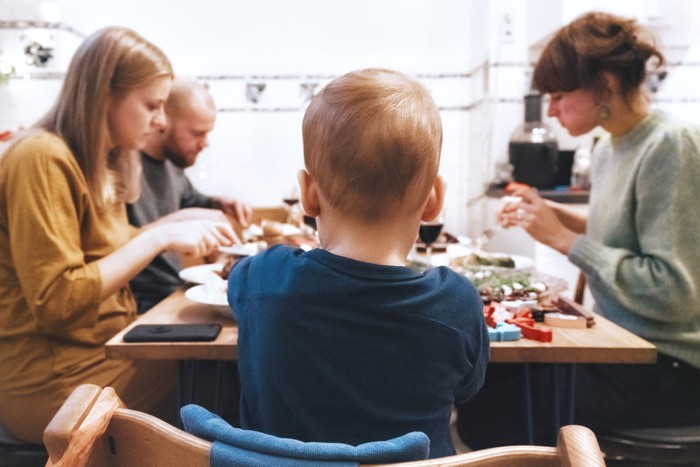view on young family eating meal with friends at table