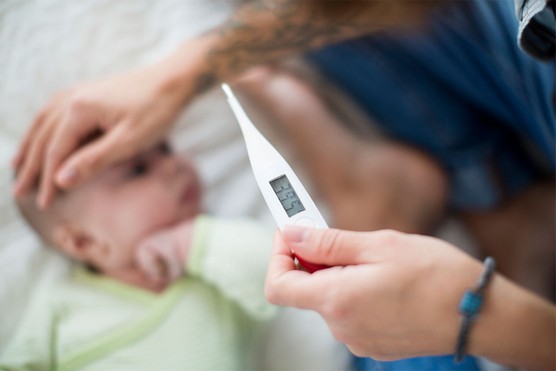 parent taking child's temperature to check for fever