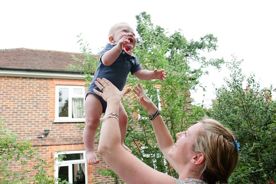 mum throwing baby in the air