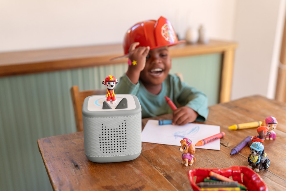 will new tonies work on toniebox A child wearing a Paw Patrol hat laughing while drawing and listening to Paw Patrol on Toniebox 2