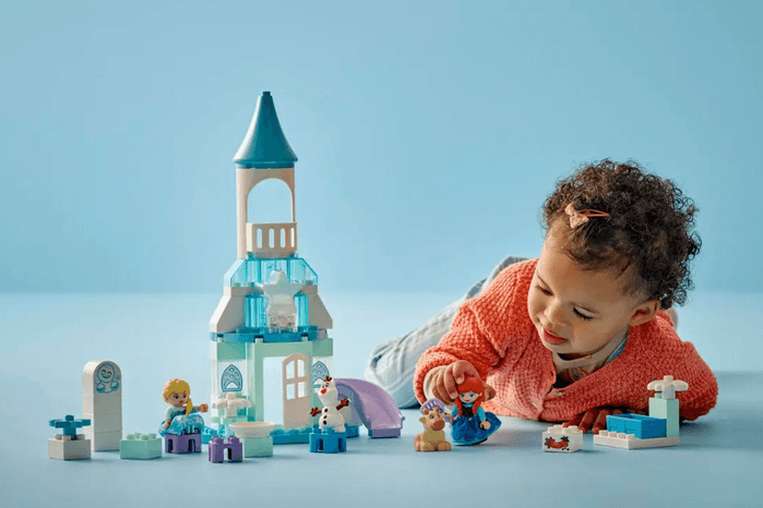 Child playing with Anna and Elsa's Frozen castle party LEGO set